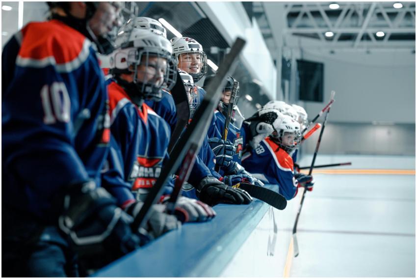 A youth ice hockey team wearing blue jerseys and h