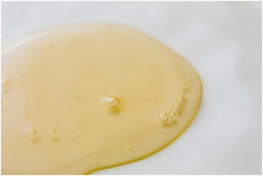 Close-up of a golden liquid with bubbles on a whit