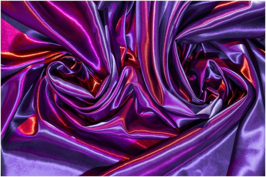 Shining purple and red silk fabric folds create a