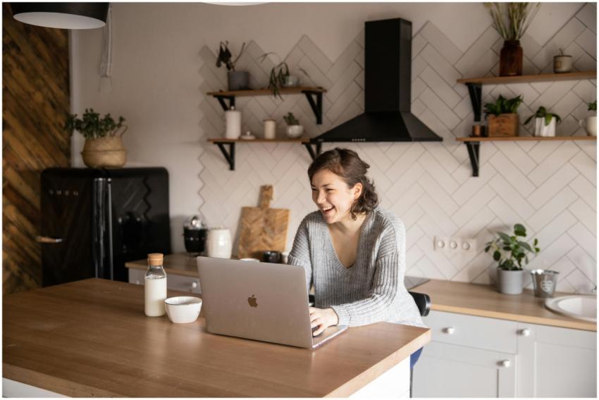 Young female in gray sweater laughing while sittin