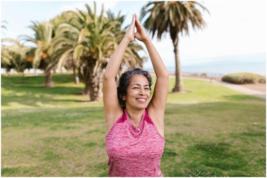 Elderly woman enjoying yoga in a sunny park, highl