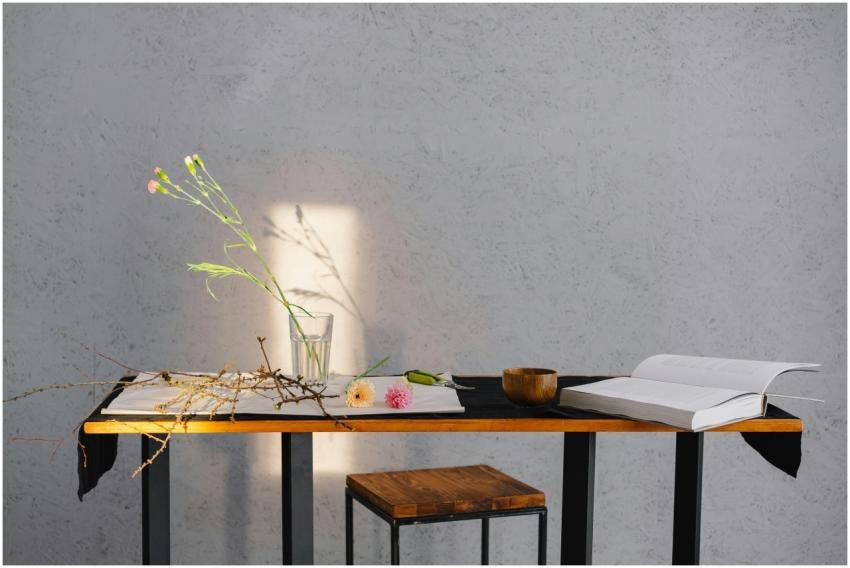 A minimalist scene of a table with flowers, an ope