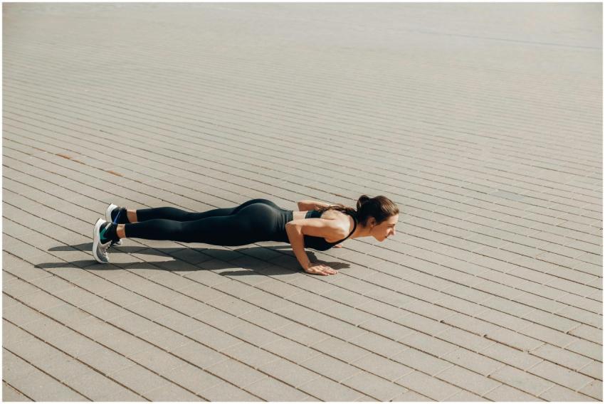 Fit woman in activewear performing push-ups outdoo