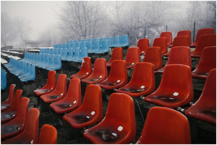 Rows of empty colorful stadium seats covered in fr