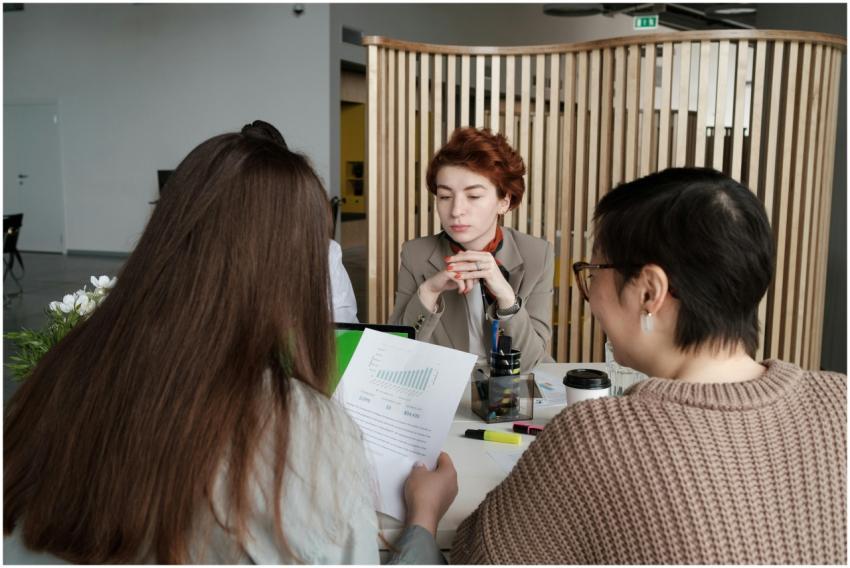 Three women discussing business plans in a modern