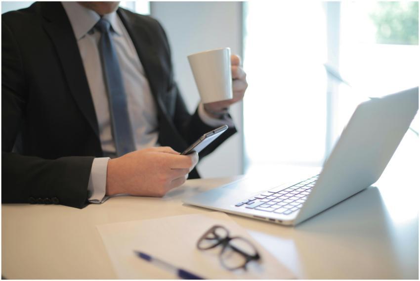 A businessman in a black suit working at a modern