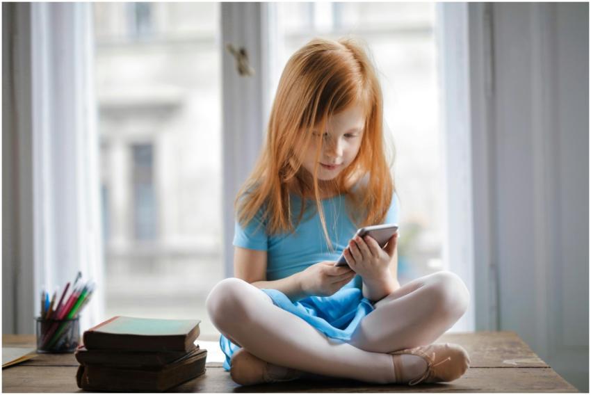 Red haired charming schoolgirl in blue dress brows