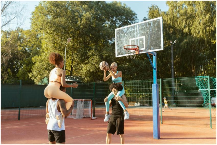 Group of young adults having fun playing basketbal