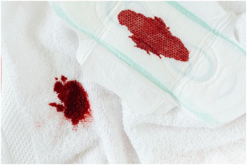 Close-up of a sanitary pad and blood stain on whit