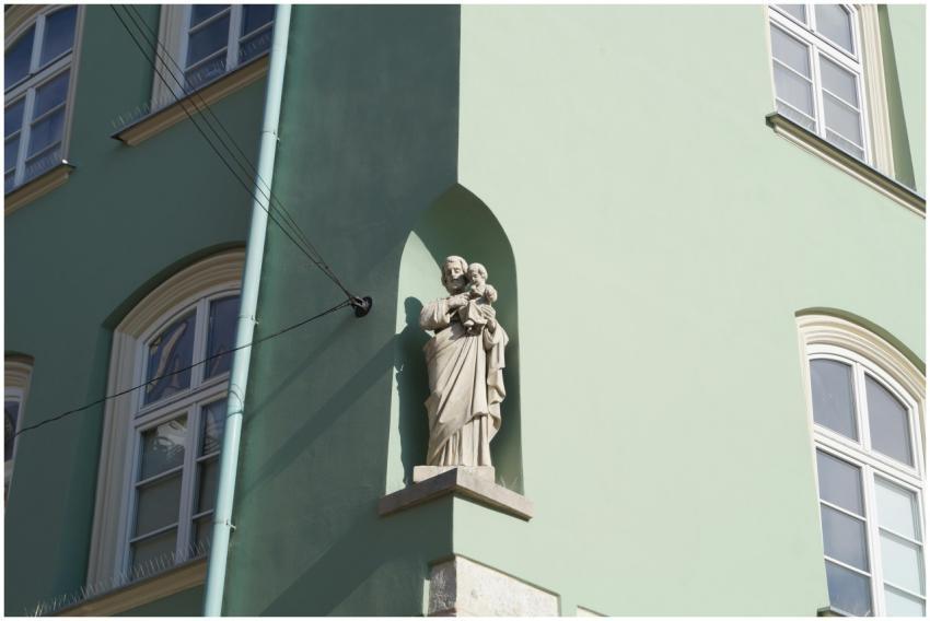 A religious statue on a Kraków building showcasing