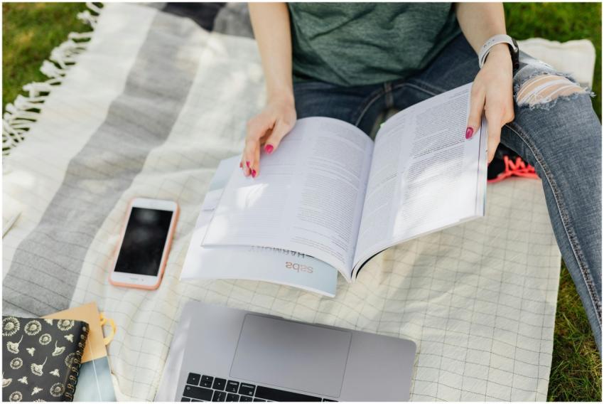 A young woman is focused on studying outdoors with