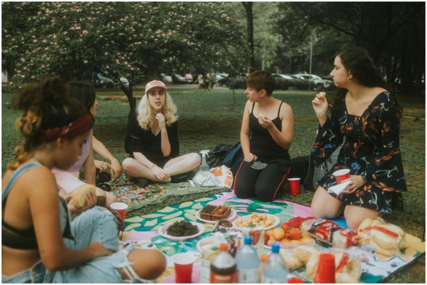 A group of women enjoying a picnic at the park wit