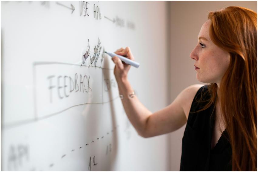 Focused woman writing on a whiteboard during a bus