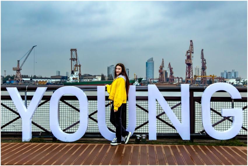 A young woman poses next to large letters spelling