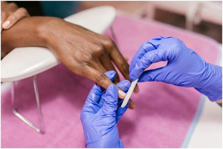 Close-up of hand receiving a manicure with latex g