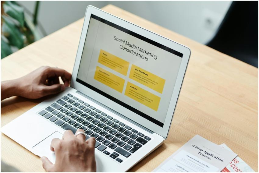 A person using a laptop to review social media mar