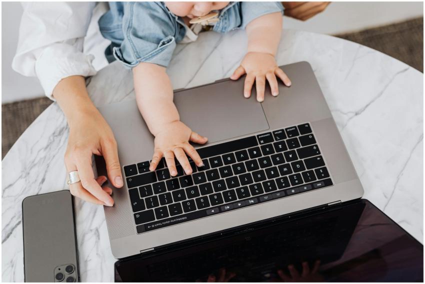 Top view of a parent and a child's hands on a lapt