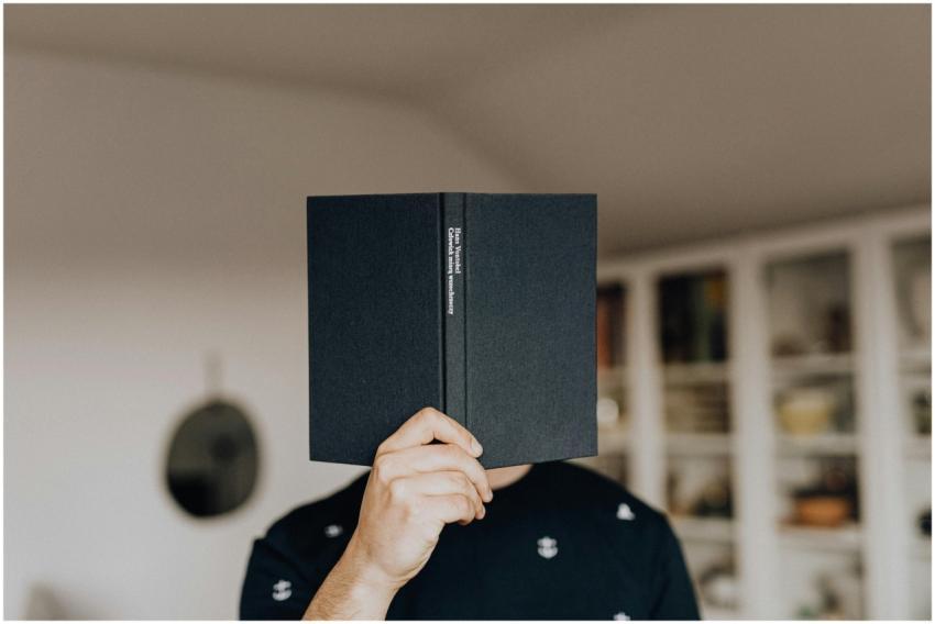 Faceless male holding opened black book in hand co