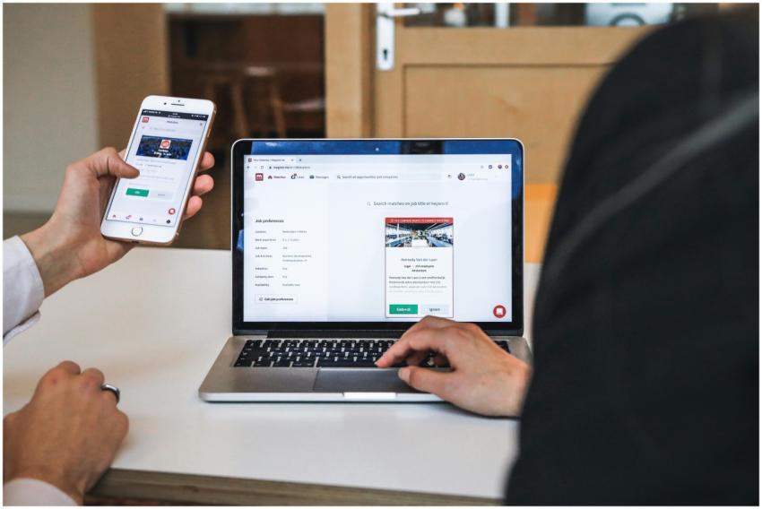 Hands using smartphone and laptop for digital brow