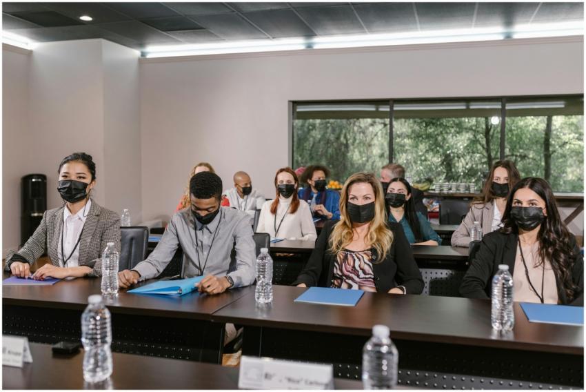 A group of masked professionals in a business meet