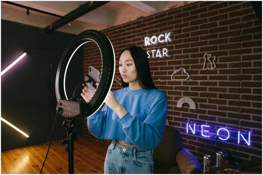 Asian woman influencer sets up a ring light in a n