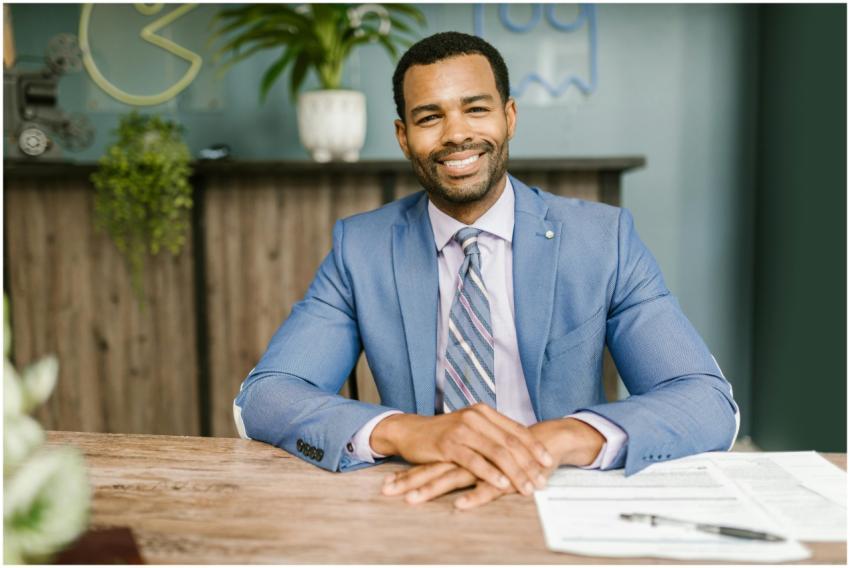 Smiling businessman in office attire sitting at a