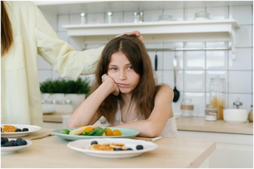 Young girl looking displeased with breakfast in a