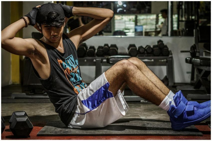 A young man performing sit-ups in a Manila gym, sh