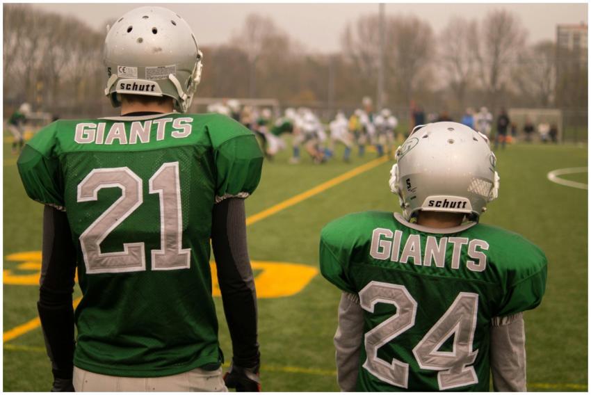 Two football players, wearing green Giants jerseys