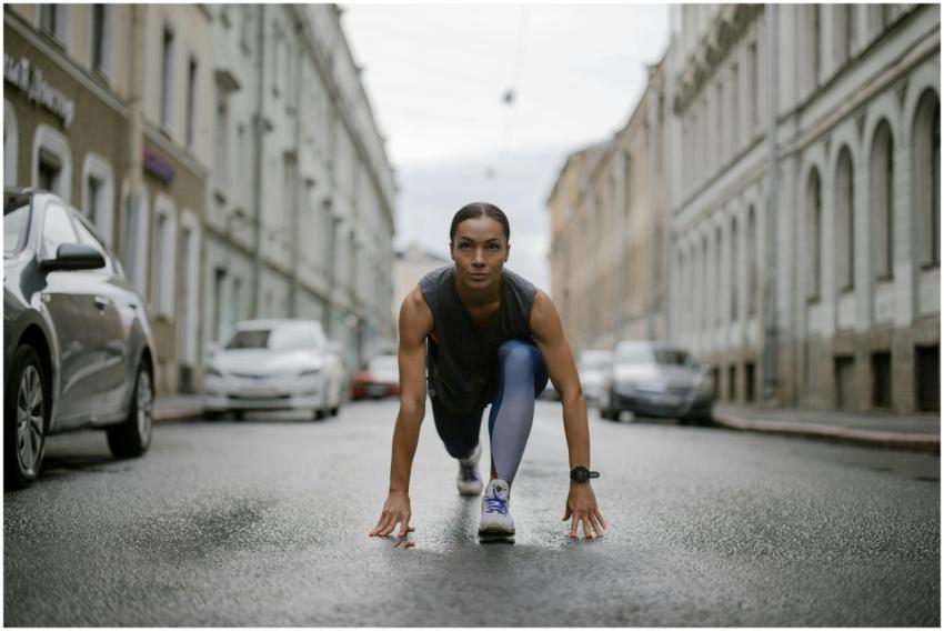 Woman in activewear poised for a run on a city str
