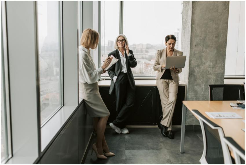 Three women in office attire collaborating near la