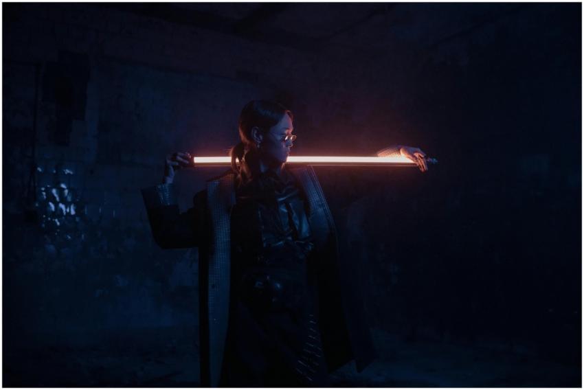 A stylish individual poses with a neon light in a