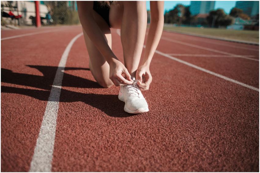 Close-up of a woman tying her shoes on a running t
