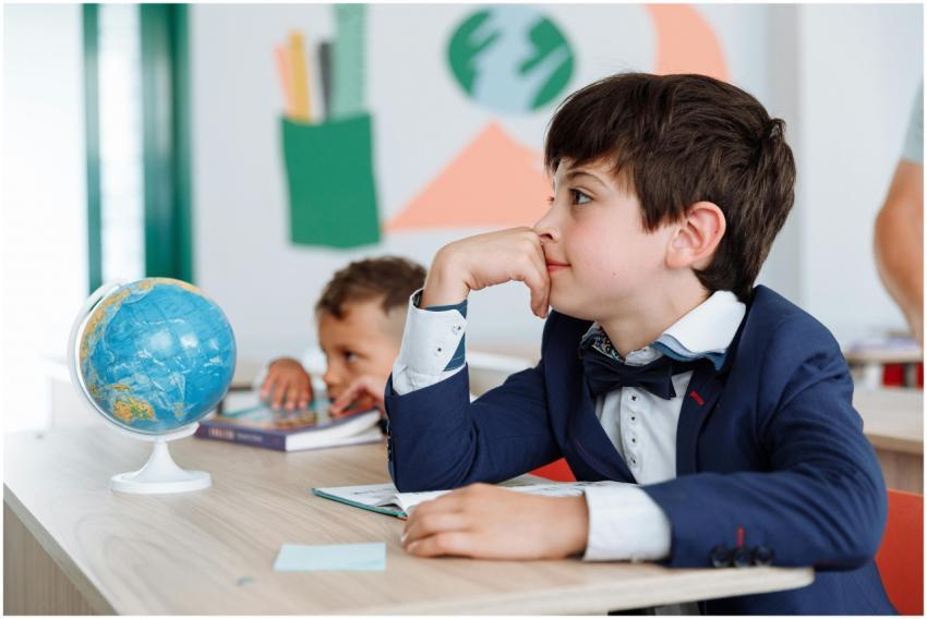 Two boys engaged in a classroom setting with books