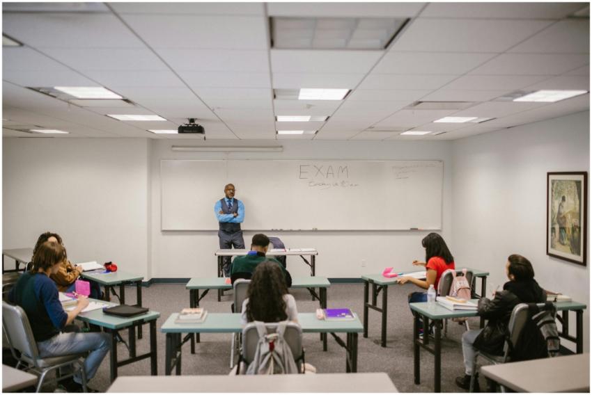 A classroom setting with a teacher proctoring an e