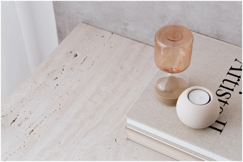 A serene minimalist setup with an hourglass, candl