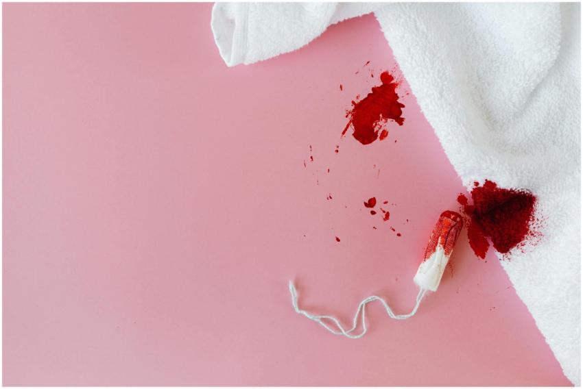 Tampon with blood stain on pink background highlig