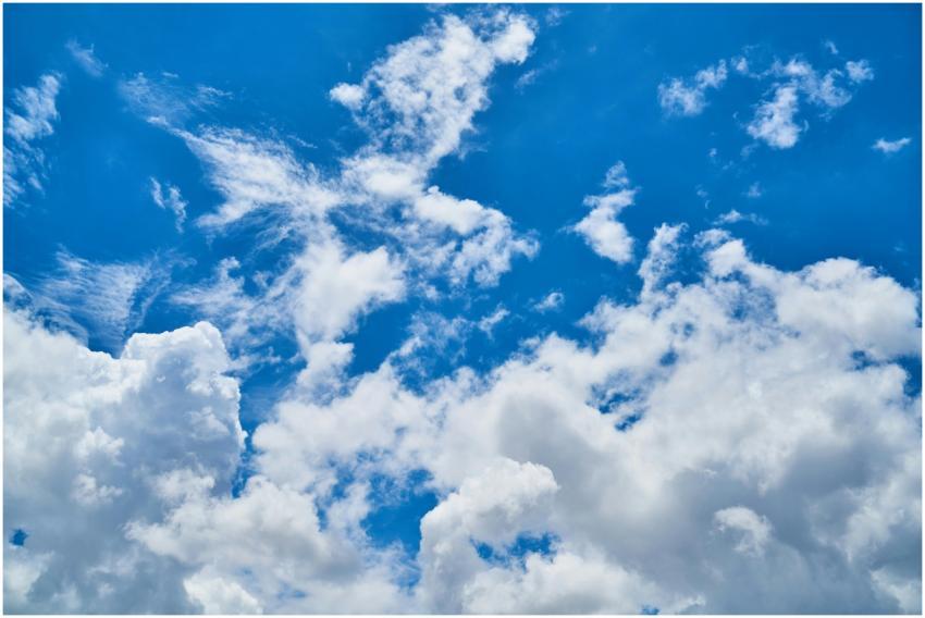 Vibrant cumulus clouds scattered across a clear bl