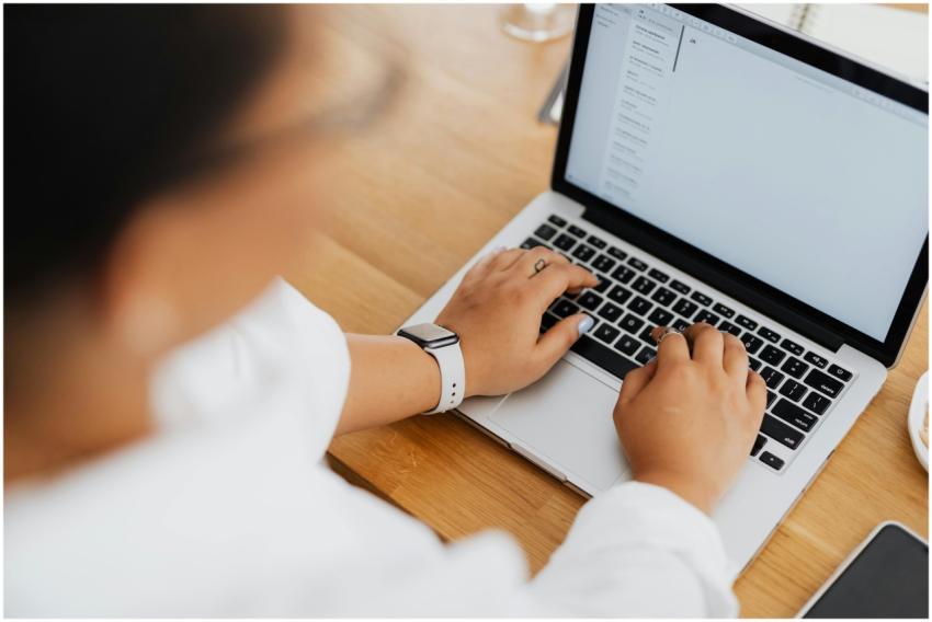 High angle shot of a person typing on a laptop, fo