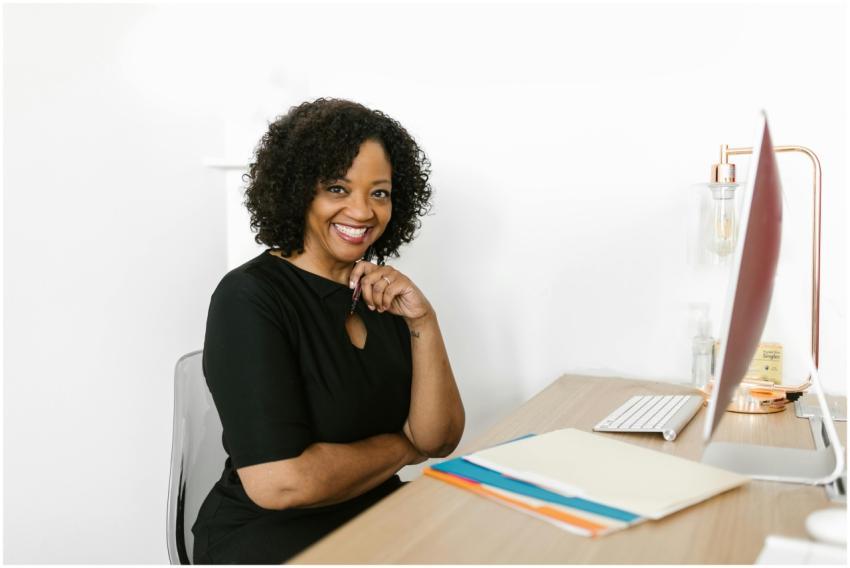 Happy woman sitting at a desk in a bright modern o