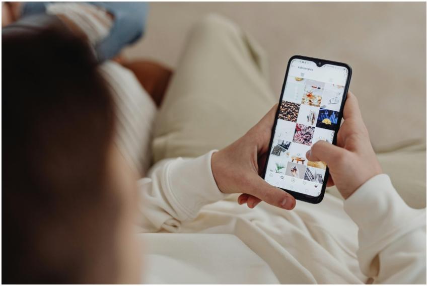 Person using smartphone to browse Instagram indoor