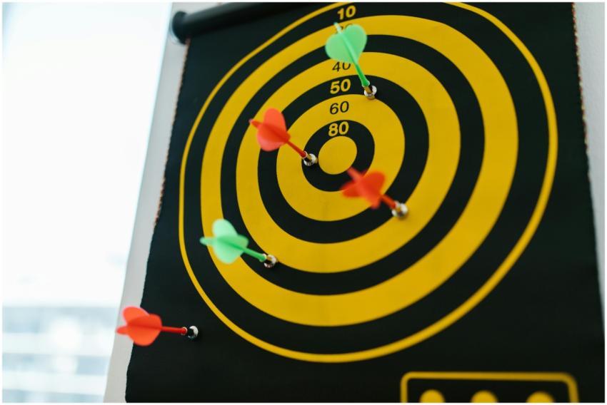 Vibrant darts stuck in a yellow and black dartboar
