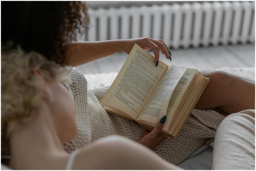 A person reading a book indoors, enjoying a relaxi