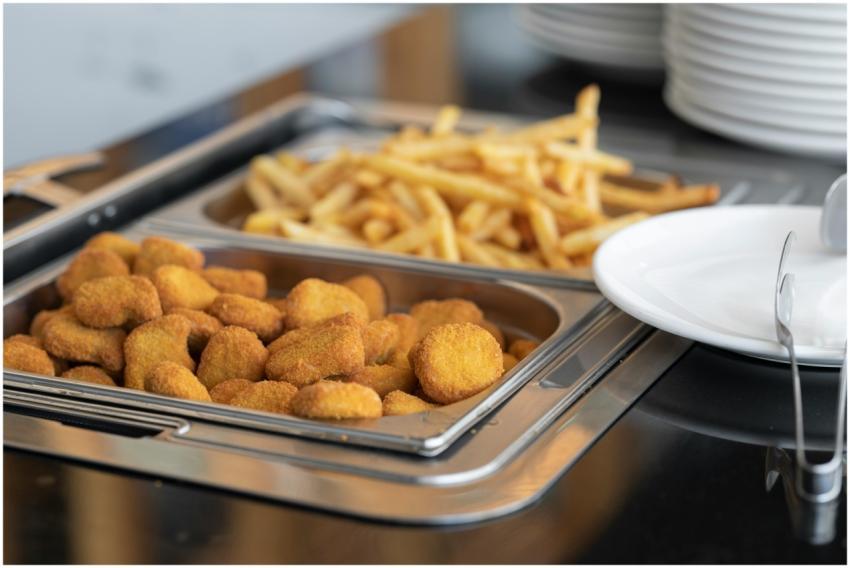 Close-up of crispy nuggets and French fries in a b