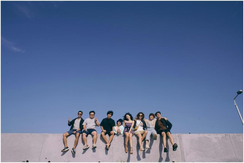 A group of friends sitting on a wall, enjoying the