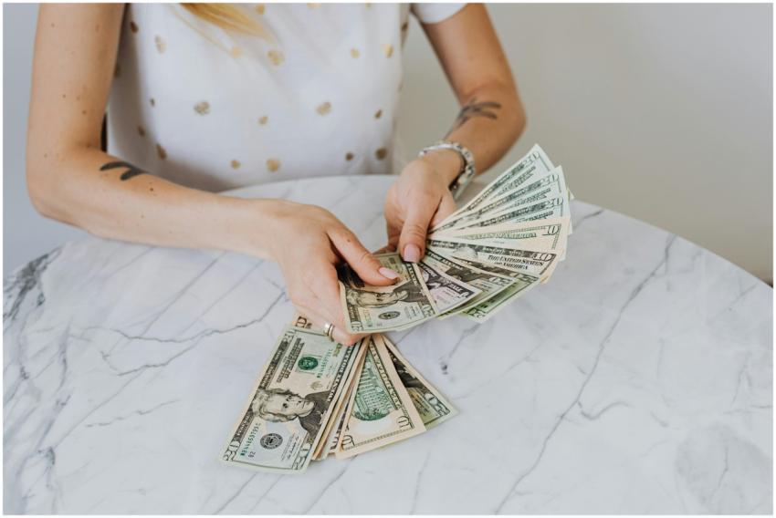 Close-up of a person counting US dollar bills on a