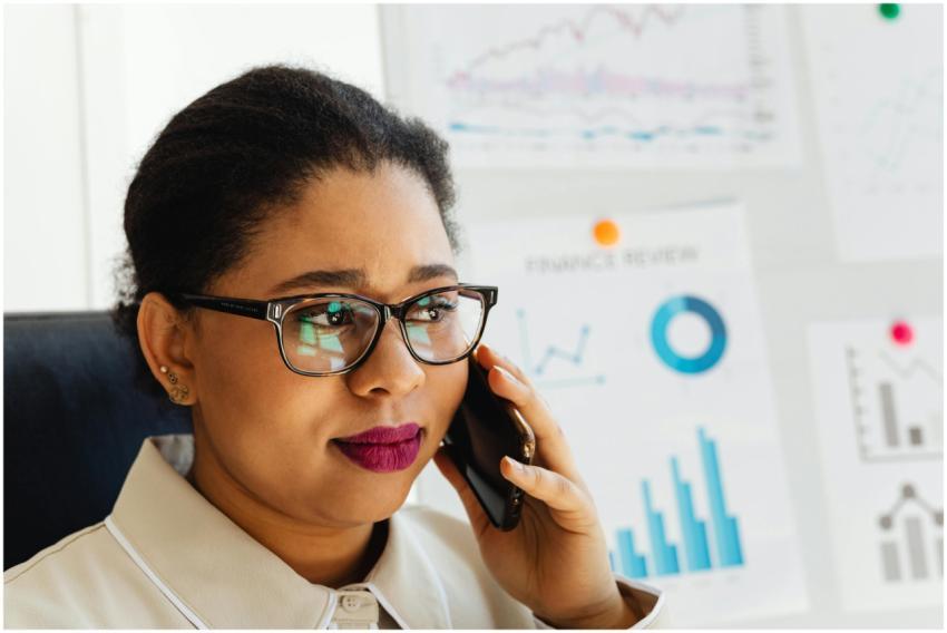 Focused woman in glasses discusses financial graph