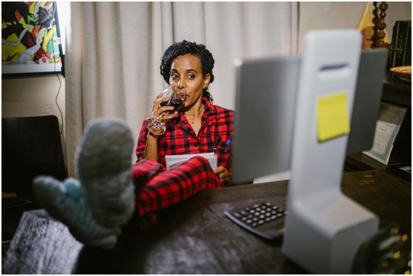 Woman in red pajamas relaxing with wine at a home