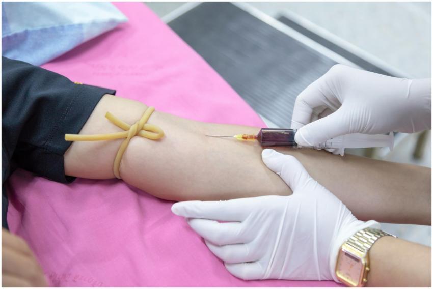 A medical professional takes a blood sample from a