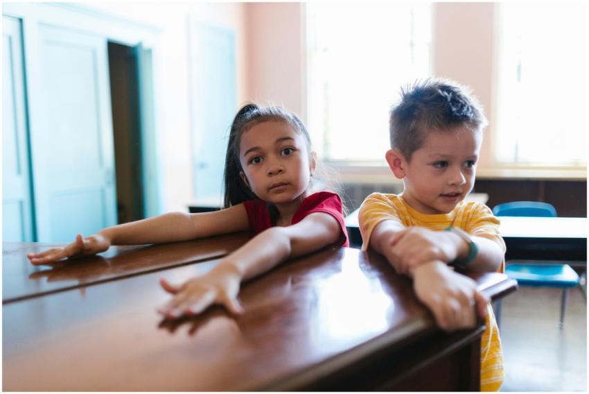 Two children sitting at a classroom table, focused